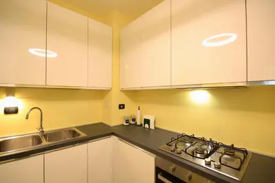 a kitchen with white cabinets and a sink at HC - CloHouse Spacious Flat in Rome