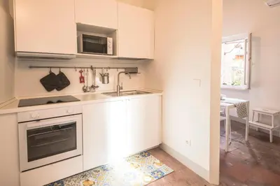 a kitchen with white cabinets and a sink at Casa degli Spagoli Navona Square in Rome