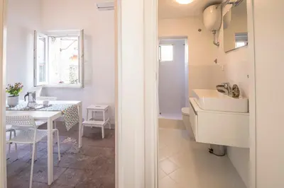 a white bathroom with a table and a sink at Casa degli Spagoli Navona Square in Rome