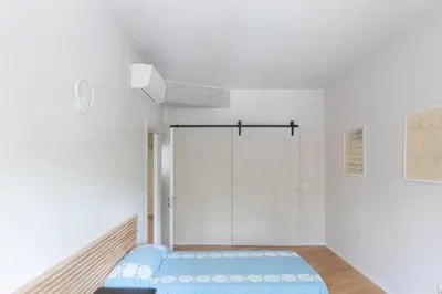 a white room with a blue bed in it at Modern Spacious Apartment on the Tevere in Rome