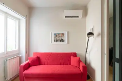 a red couch in a living room with a window at Modern Spacious Apartment on the Tevere in Rome