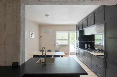 a kitchen with black cabinets and a counter top at Modern Spacious Apartment on the Tevere in Rome