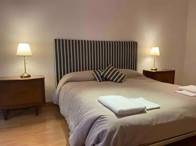 a bedroom with a large bed with two lamps on tables at St Peter s Home, nel cuore della Città Eterna in Rome