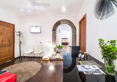 a living room with white walls and an archway at Sant'Angelo Apartments in Rome