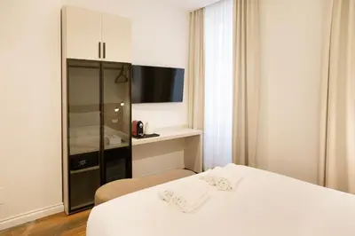 a bedroom with a white bed and a cabinet at 56 Orange Street Luxury Accommodation in Rome