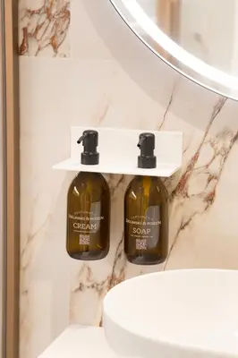 two bottles of soap on a wall next to a sink at 56 Orange Street Luxury Accommodation in Rome