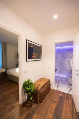 a bedroom with a bed and a ottoman in a room at 56 Orange Street Luxury Accommodation in Rome