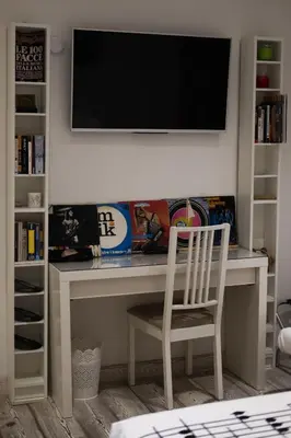 a white desk with a mirror and a television on a wall at Big Johnny B in Rome