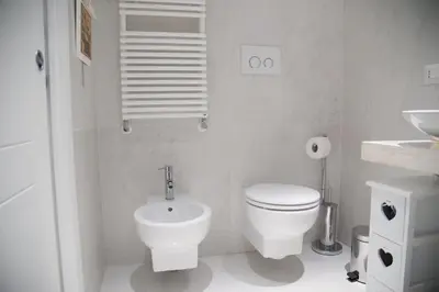 a white bathroom with a toilet and a sink at Big Johnny B in Rome