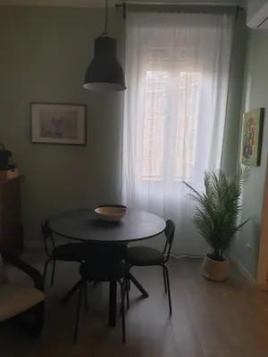 a table and chairs in a room with a window at Appartamento La Doriana in Rome