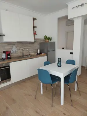 a kitchen with a white table and blue chairs at Casa Bibbi in Rome