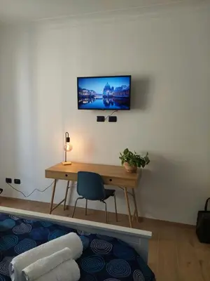 a desk with a chair and a television on a wall at Casa Bibbi in Rome