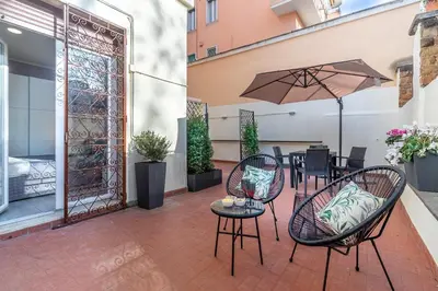 a patio with a table and chairs and an umbrella at Casa Gabea in Rome