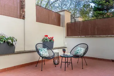 two chairs and a table with a glass of wine on a patio at Casa Gabea in Rome