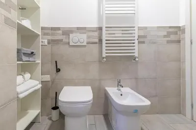 a bathroom with a white toilet and a sink at Casa Gabea in Rome