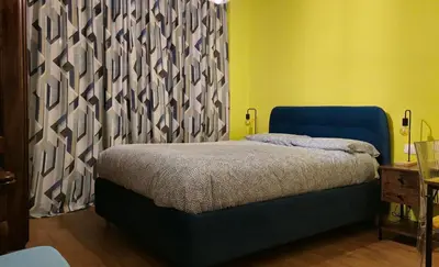 a bedroom with a blue bed and a curtain at Cornelia Battistini - Ampia camera con bagno privato in Rome