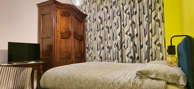 a bedroom with a bed and a dresser with a television at Cornelia Battistini - Ampia camera con bagno privato in Rome