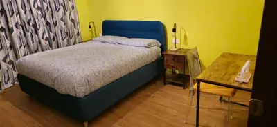 a bedroom with a blue bed and a table at Cornelia Battistini - Ampia camera con bagno privato in Rome
