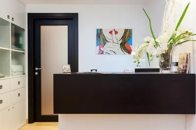 a black dresser in a kitchen with a vase of flowers at Domus Best Guest House in Rome