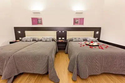 a room with two beds with red roses on them at Domus Best Guest House in Rome