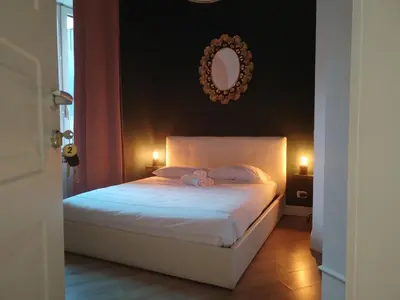 a bedroom with a white bed with a mirror on the wall at Enotri Guest House - Rome in Rome