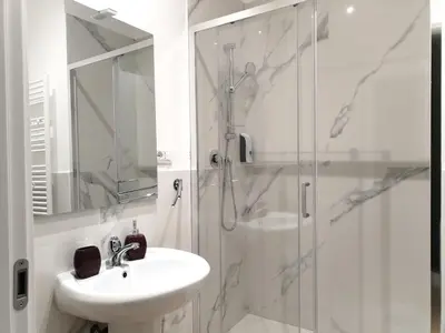 a white bathroom with a sink and a shower at Enotri Guest House - Rome in Rome