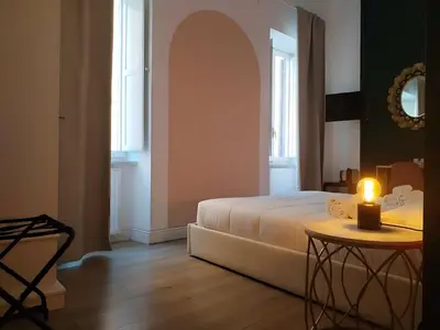 a bedroom with a bed and a candle on a table at Enotri Guest House - Rome in Rome