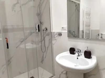 a white bathroom with a sink and a shower at Enotri Guest House - Rome in Rome
