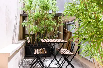 a table and chairs on a balcony with plants at New Modern in Trastevere with Garden in Rome