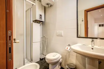 a white bathroom with a toilet and a sink at Suite Experience San Giovanni Apartments in Rome