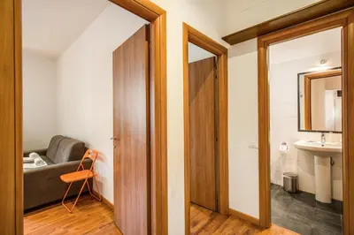 a bathroom with a couch and a sink in a room at Suite Experience San Giovanni Apartments in Rome