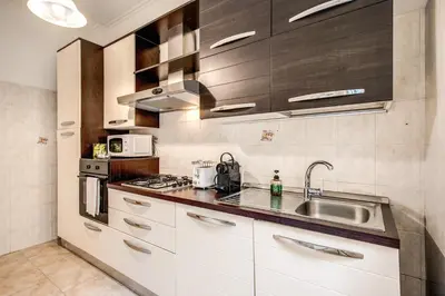 a kitchen with white cabinets and a sink at Suite Experience San Giovanni Apartments in Rome