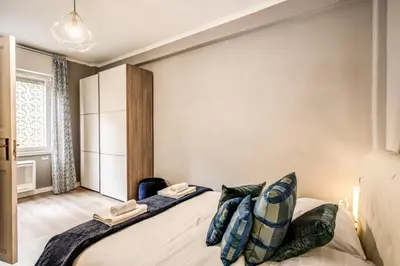 a bedroom with a large bed with blue pillows at Suite Experience San Giovanni Apartments in Rome