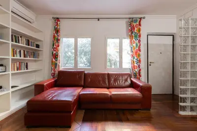 a brown leather couch in a living room with bookshelves at Elegant apartment in Trastevere in Rome