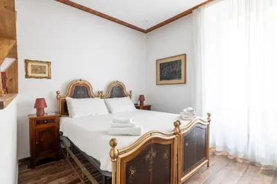 a bedroom with a large bed with white sheets at Cesare Balbo - B&D Apts in Rome