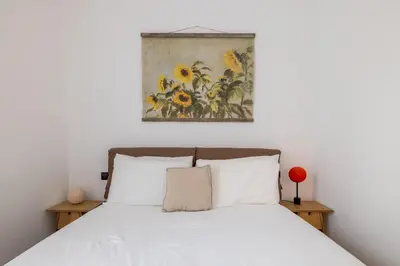 a bedroom with a bed with a painting above it at Cesare Balbo - B&D Apts in Rome