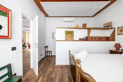 a bedroom with white walls and a bed in a room at Cesare Balbo - B&D Apts in Rome