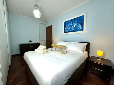 a bedroom with a large white bed with a table on it at 10 Min to Metro Cozy Apartment Near City Center in Rome