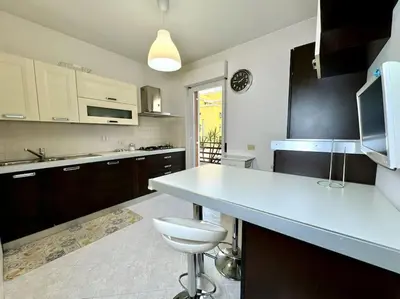 a kitchen with a white counter and a white stool at 10 Min to Metro Cozy Apartment Near City Center in Rome