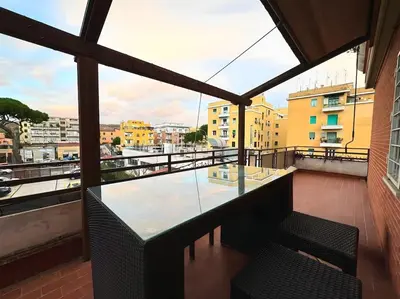 a balcony with a table and chairs on a building at 10 Min to Metro Cozy Apartment Near City Center in Rome