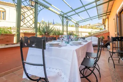 a table in a conservatory with a white table cloth at Trevi Terrace Penthouse in Rome