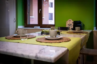 a table with plates and glasses on a green wall at Trevi Terrace Penthouse in Rome