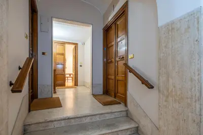a hallway with stairs and a wooden door at Trevi Terrace Penthouse in Rome
