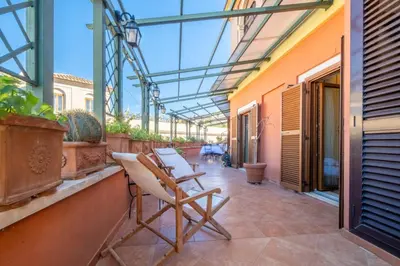 a patio with chairs and a table on a building at Trevi Terrace Penthouse in Rome