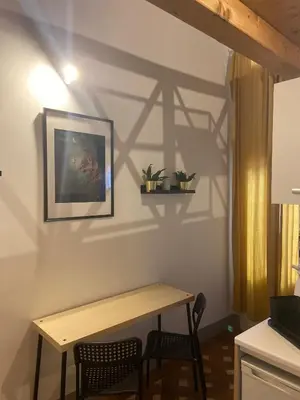 a table and chairs in a kitchen with a shadow on the wall at little house in trastevere in Rome