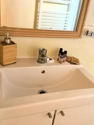 a white sink in a bathroom with a mirror at little house in trastevere in Rome