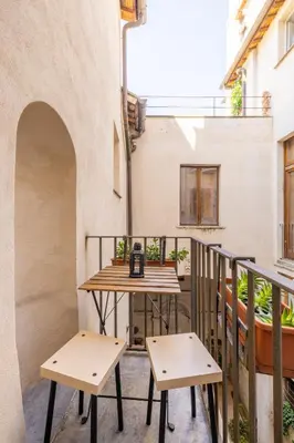 a balcony with a table and two benches at little house in trastevere in Rome