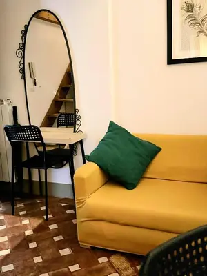 a room with a couch and a table with a mirror at little house in trastevere in Rome