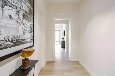 a hallway with white walls and a large painting on the wall at Roma Essence Vaticano e Comfort in Rome