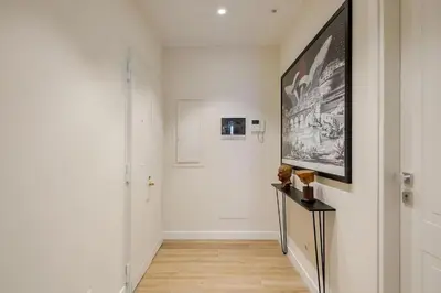 a hallway with a white wall with a picture on the wall at Roma Essence Vaticano e Comfort in Rome